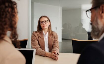 Young woman attending a job interview in a modern office, showcasing confidence and professionalism.